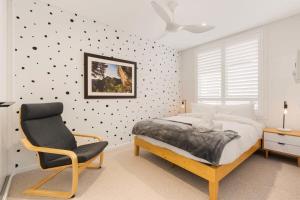 um quarto com uma cama e uma cadeira em A Light Filled Contemporary Design Apartment em Sidney