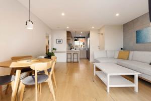 a living room with a couch and a table at Coogee Beach Cosy Home in Sydney +6 photos