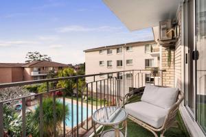 a balcony with a chair and a pool at Coogee Beach Cosy Home in Sydney