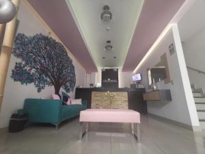 a lobby with a blue couch and a tree on the wall at LOS ARCES HOTEL in Lima