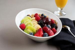 a bowl of fruit on a table with a drink at Sheraton Suites Old Town Alexandria in Alexandria