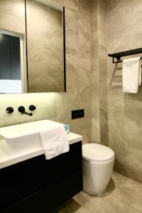 a bathroom with a sink and a toilet and a mirror at Lux & Quiet Apartment in, Potts Point in Sydney