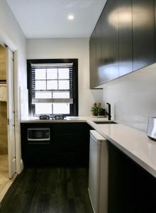 a kitchen with black and white cabinets and a window at Lux & Quiet Apartment in, Potts Point in Sydney