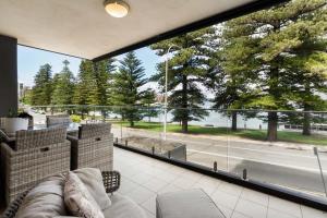 a living room with a couch and a large window at Stylish Manly Apartment with Harbour Views in Sydney