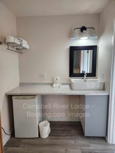 uma casa de banho com um lavatório e um espelho em Campbell River Lodge em Campbell River