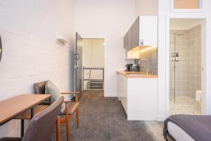 Il comprend une petite cuisine et une salle à manger avec une table et des chaises. dans l'établissement Darlinghurst Studio 4 City Stay, à Sydney