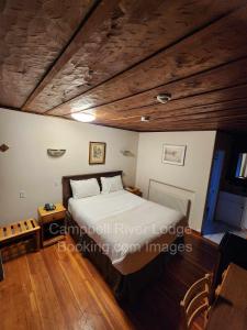 una camera con letto e soffitto in legno di Campbell River Lodge a Campbell River