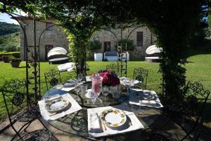 einen Tisch mit Platten und Blumen darüber in der Unterkunft Ferienhaus für 10 Personen in Montecatini Tere, Toskana Provinz Pistoia in Montecatini Terme