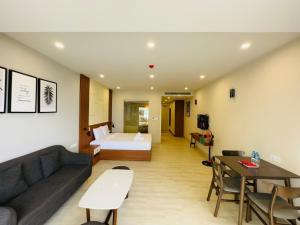 sala de estar con sofá y cama en Gold Coast Serviced Apartment Nha Trang, en Nha Trang
