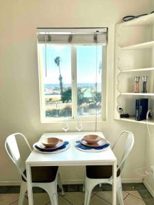 een witte tafel met twee stoelen en een raam bij Minimalist 1 bed by Airport & Old Town in San Diego
