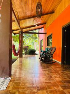 una veranda aperta con sedie e parete arancione di Villa Toscana a Santa Rosa