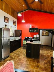 una grande cucina con pareti rosse ed elettrodomestici in acciaio inossidabile di Villa Toscana a Santa Rosa