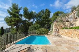a swimming pool in front of a house with a fence at Luxury 3 bedroom villa with pool in Spéracèdes