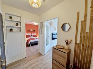 Zimmer mit einem Schlafzimmer mit einem Bett und einem Spiegel in der Unterkunft L'Hacienda / F2 de standing Cergy /parking inclus in Cergy