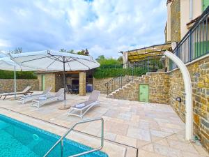 a swimming pool with two chairs and an umbrella at Ferienhaus mit Privatpool für 10 Personen ca 200 qm in Bartolici, Istrien Binnenland von Istrien in Motovun