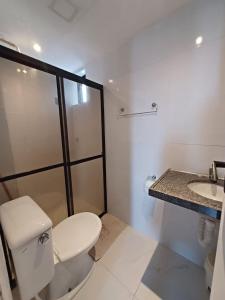 een witte badkamer met een toilet en een wastafel bij Apartamentos na Praia de Camboinha/ Cabedelo/João Pessoa in Cabedelo