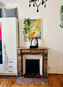 a fireplace with a vase on top of it in a room at Studio animé et nifty à Paris/Denfert Rochereau in Paris