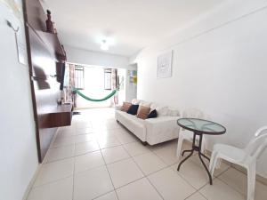 een woonkamer met een witte bank en een tafel bij Apartamentos na Praia de Camboinha/ Cabedelo/João Pessoa in Cabedelo