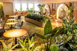 a room with tables and chairs and plants at Keio Plaza Hotel Tokyo in Tokyo