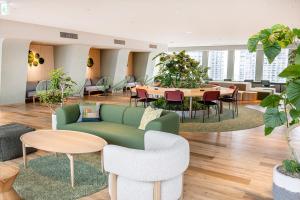 東京にある京王プラザホテルの緑のソファ、テーブル、椅子が備わるロビー