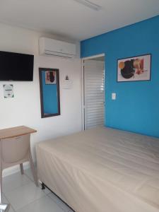um quarto com uma cama e uma parede azul em Flat Rainha da Serra em Bezerros
