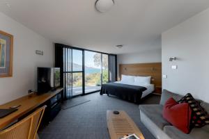 a hotel room with a bed and a tv at Edge of the Bay Resort in Coles Bay