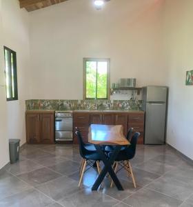 a kitchen with a table and chairs and a refrigerator at Casa Tres Tucanes in San Isidro
