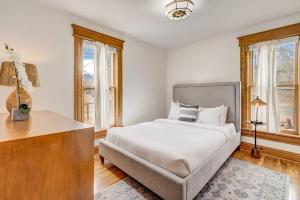 a white bedroom with a bed and windows at Close to All the Action Walk to Garden of the Gods in Colorado Springs