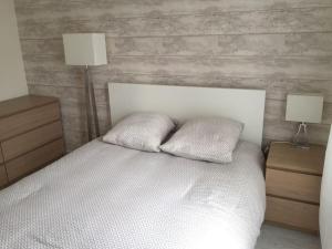 ein Schlafzimmer mit einem weißen Bett mit zwei Kissen in der Unterkunft DISNEYLAND Paris (5 min from the park) in Chessy