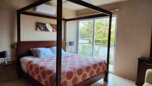 a bedroom with a canopy bed with a window at POOL HOUSE VALLADOLID in Valladolid