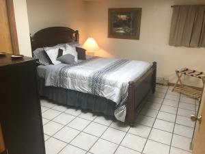 a bedroom with a bed and a lamp on a tiled floor at West Main Lodge, 2 Bedrooom in Lead