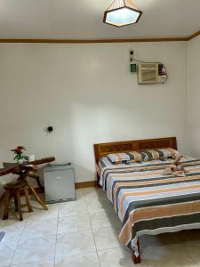 sypialnia z 2 łóżkami i stołem w obiekcie Ana's Bungalow w mieście Siquijor