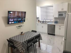 cocina con mesa, fregadero y nevera en Ground Lvl Brand New Suite - Two Bedroom en Surrey