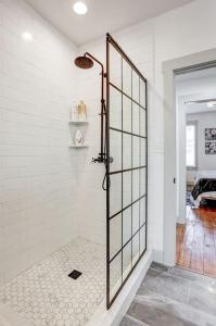 La salle de bains est pourvue d'une douche avec une porte en verre. dans l'établissement Luxury Manor on Mulberry in the heart of Downtown Lanc, à Lancaster