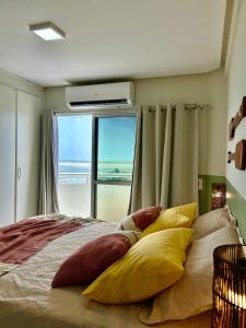 a bedroom with a bed with pillows and a window at (106) Exclusivo Vista mar na praia da Litorânea in Pimenta