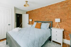 Un dormitorio con una pared de ladrillo y una cama en Getaway on Grant heart of Downtown with parking, en Lancaster