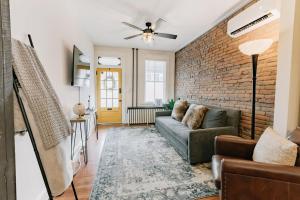 a living room with a couch and a brick wall at Comfy renovated townhome - heart of Downtown Lancaster in Lancaster