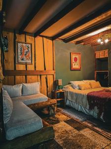 a bedroom with two beds and a couch in it at Cabañas Pewma Futrono in Futrono