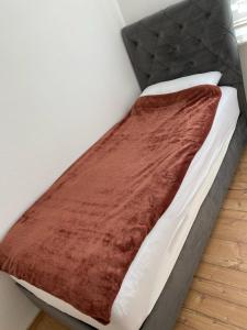 a bed with a brown blanket on top of it at A cozy room with brand new furniture in Frankfurt/Main