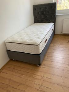 a bed sitting on a floor in a room at A cozy room with brand new furniture in Frankfurt/Main