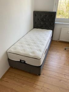 a bed sitting in a corner of a room at A cozy room with brand new furniture in Frankfurt/Main