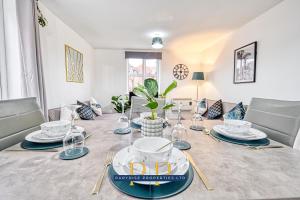 a dining room with a table with plates and glasses at The Sale Symphony Suite - By Parydise Properties - Business or Leisure Stays - Sleeps 6 - Sale, Manchester in Sale