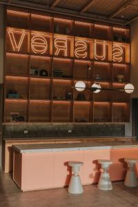 a restaurant with a counter with stools in front at Versus Hotel in Medellín