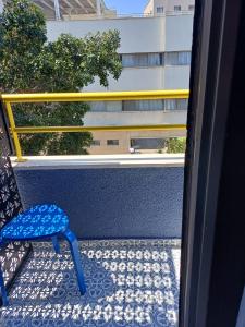 una silla azul sentada en un balcón con ventana en Ninna palatin, en Haifa