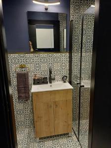 uma casa de banho com um lavatório e um espelho em Ninna palatin em Haifa
