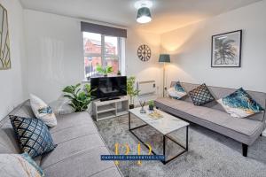 a living room with a couch and a tv at The Sale Symphony Suite - By Parydise Properties - Business or Leisure Stays - Sleeps 6 - Sale, Manchester in Sale