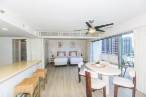 1 dormitorio y sala de estar con mesa y sillas. en Two Bedroom Condo Overlooking Ala Wai Boat Harbor, en Honolulu