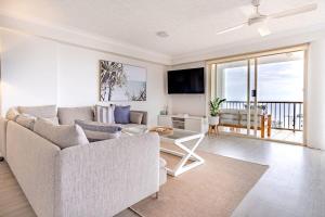 a living room with a couch and a table at Kings Beach Coast and Glasshouse Views in Caloundra