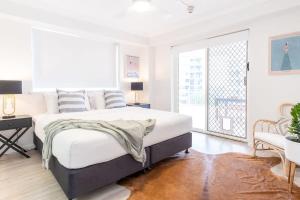 a white bedroom with a large bed and a window at Kings Beach Coast and Glasshouse Views in Caloundra