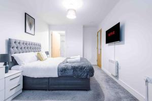 um quarto com uma cama e uma televisão de ecrã plano em Luxury 2BR Apartment in Central *FREE PARKING* em Manchester